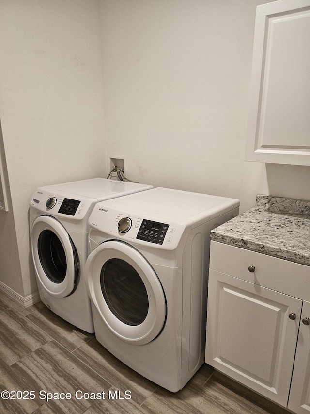 laundry room featuring cabinet space, dark wood-type flooring, and independent washer and dryer