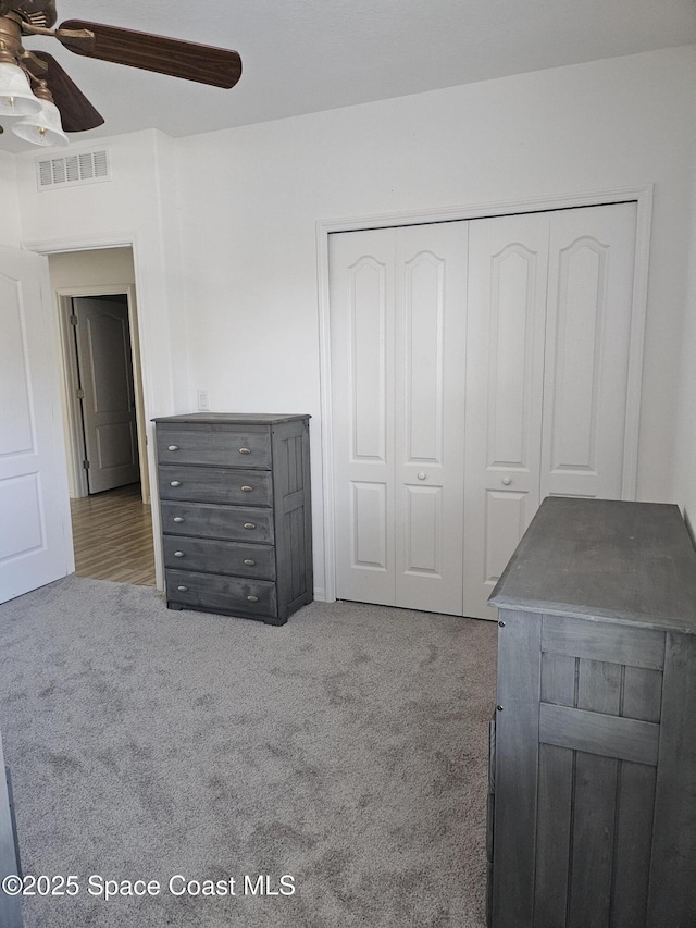 unfurnished bedroom with a ceiling fan, carpet, a closet, and visible vents