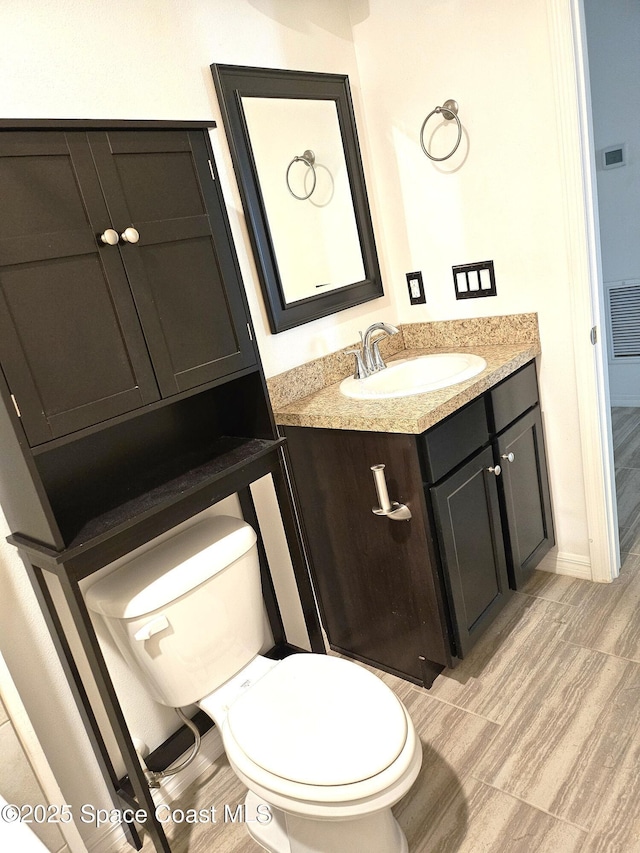 bathroom with visible vents, vanity, and toilet