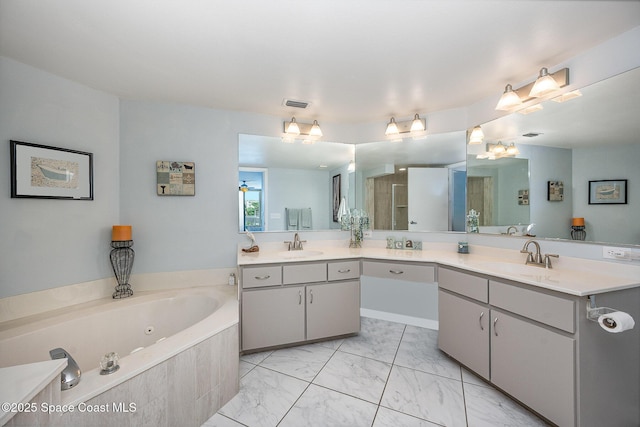 bathroom featuring a whirlpool tub, marble finish floor, visible vents, and a sink