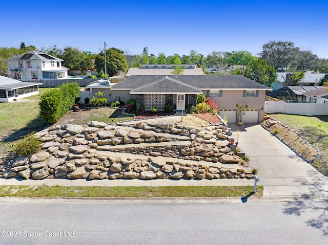 ranch-style home featuring a garage, fence, concrete driveway, and stucco siding