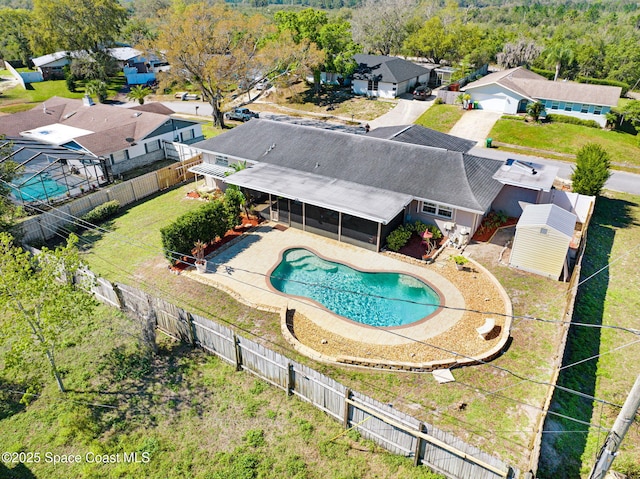 view of pool with a residential view, a patio area, a fenced backyard, and a sunroom