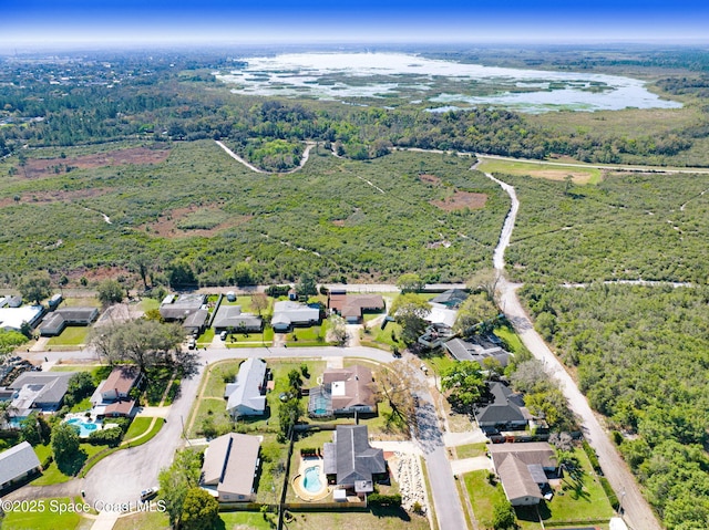 drone / aerial view with a water view, a forest view, and a residential view