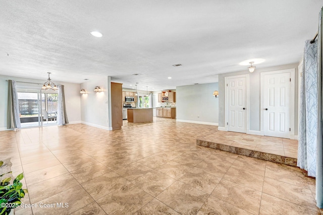 unfurnished living room with a chandelier, recessed lighting, visible vents, and baseboards