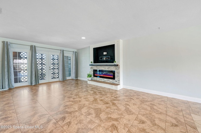 unfurnished living room featuring french doors, recessed lighting, visible vents, a glass covered fireplace, and baseboards