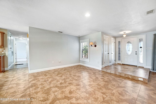 entrance foyer featuring baseboards and visible vents