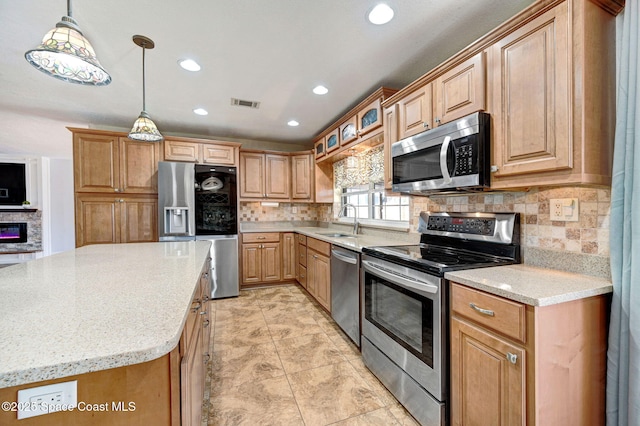 kitchen with stainless steel appliances, visible vents, a sink, and backsplash