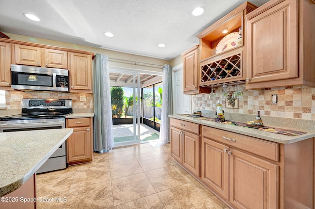 kitchen featuring a textured ceiling, light stone counters, recessed lighting, appliances with stainless steel finishes, and decorative backsplash