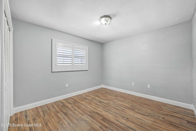 unfurnished room featuring baseboards and wood finished floors