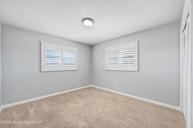 unfurnished bedroom featuring carpet floors, a closet, and baseboards