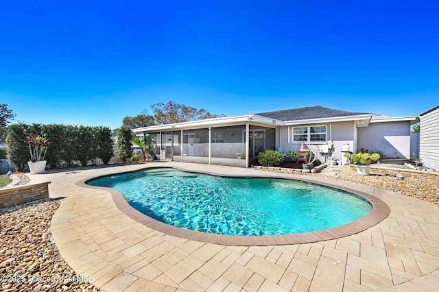 pool with a sunroom and a patio