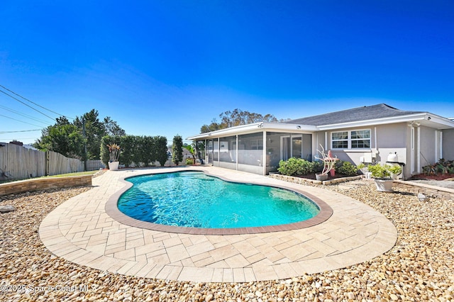 view of swimming pool with a sunroom, fence, a fenced in pool, and a patio