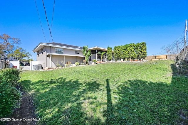 view of yard with a sunroom and fence