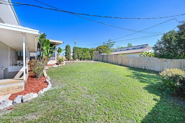 view of yard with fence and a sunroom