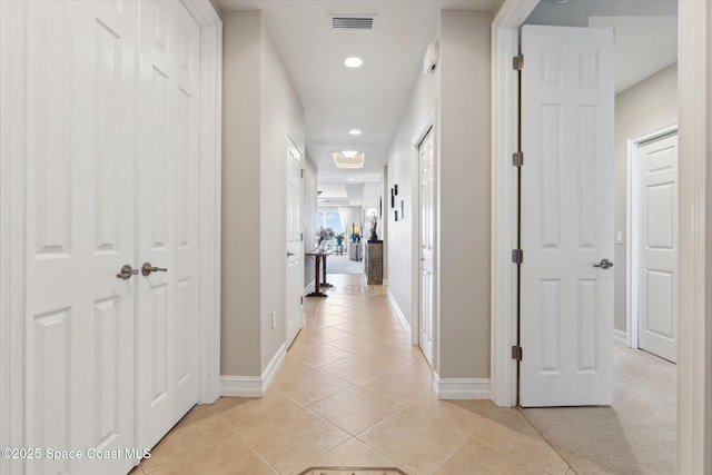 hall with light tile patterned floors, visible vents, recessed lighting, and baseboards