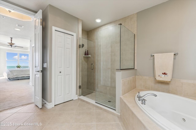 bathroom with a ceiling fan, a stall shower, tile patterned flooring, a closet, and a garden tub