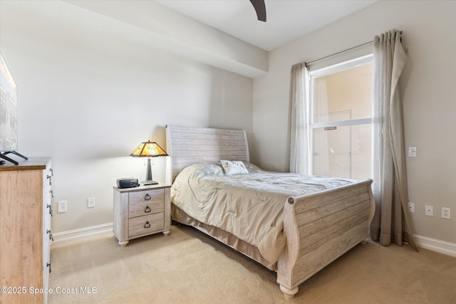 bedroom with light colored carpet, baseboards, and ceiling fan