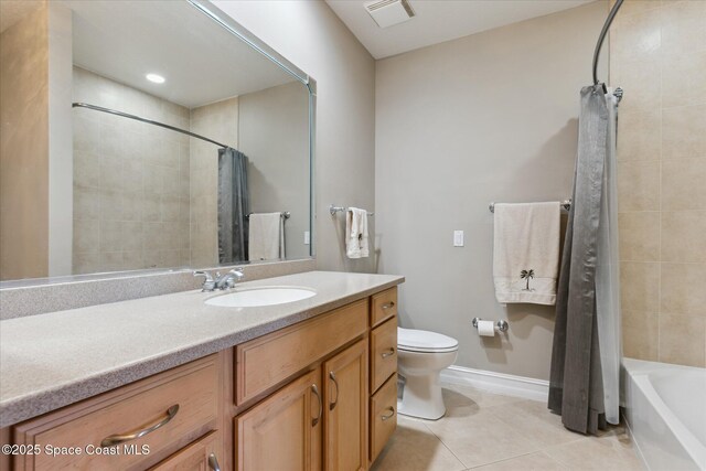 bathroom featuring baseboards, toilet, vanity, and tile patterned flooring