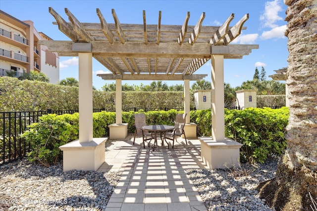 view of patio with outdoor dining space, fence, and a pergola