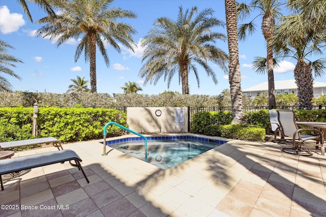 view of pool featuring a community hot tub, a patio, and fence