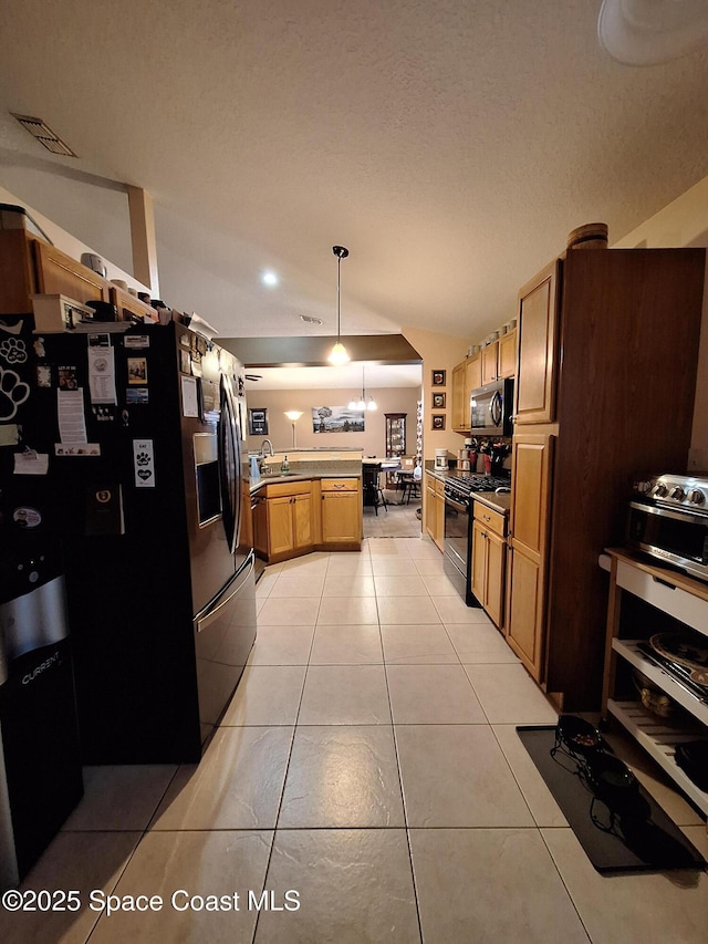 kitchen featuring a peninsula, appliances with stainless steel finishes, light tile patterned flooring, and visible vents