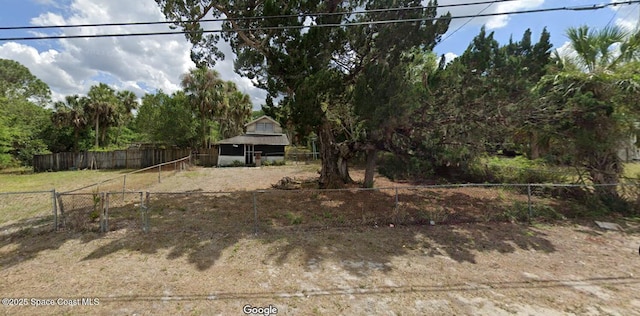 view of yard featuring fence and an outbuilding