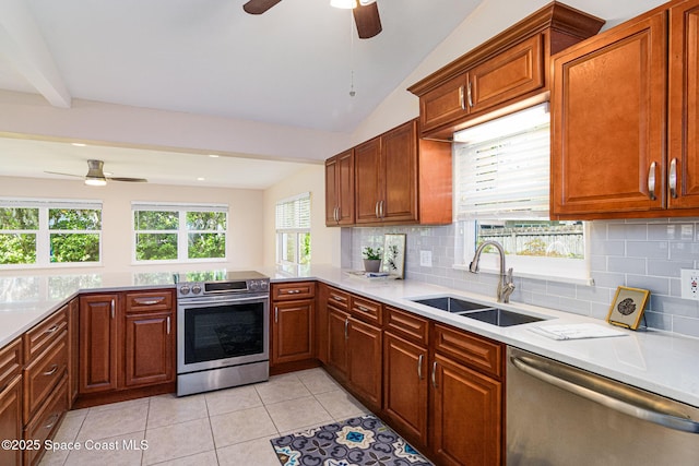 kitchen with lofted ceiling, light tile patterned floors, stainless steel appliances, a sink, and light countertops