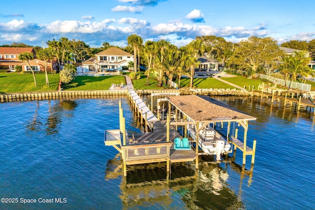 view of dock featuring a lawn, a water view, and boat lift