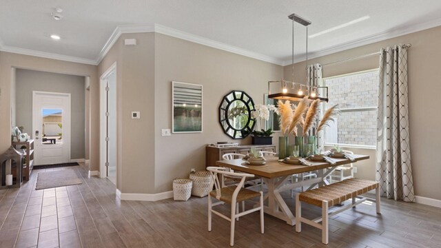 dining area featuring baseboards, wood finished floors, and crown molding
