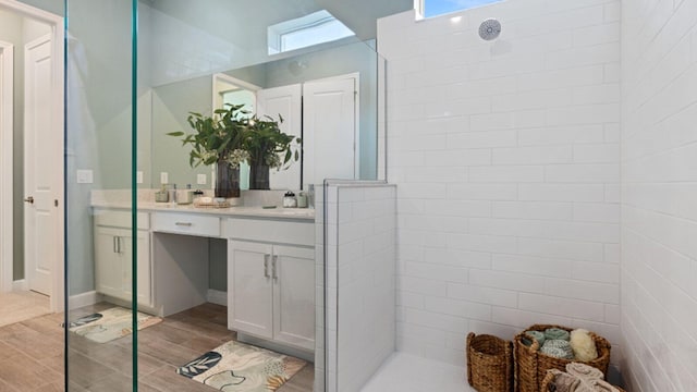 bathroom featuring walk in shower, vanity, and wood tiled floor