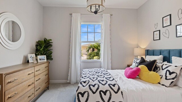 bedroom with light colored carpet and baseboards