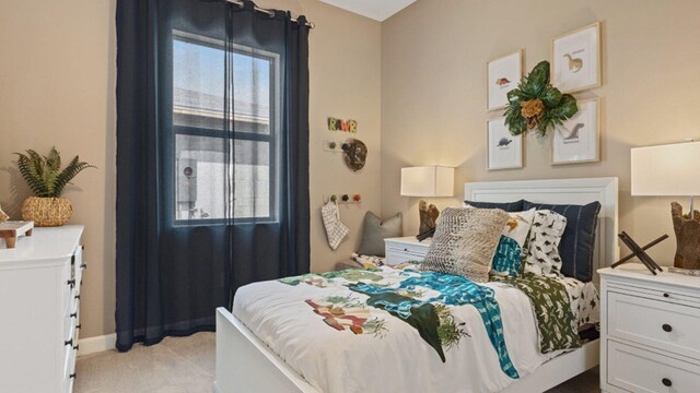 bedroom with baseboards and light colored carpet