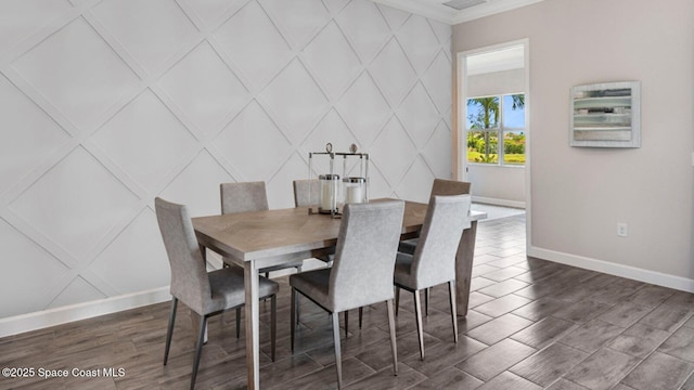 dining space featuring crown molding, dark wood-style flooring, and baseboards