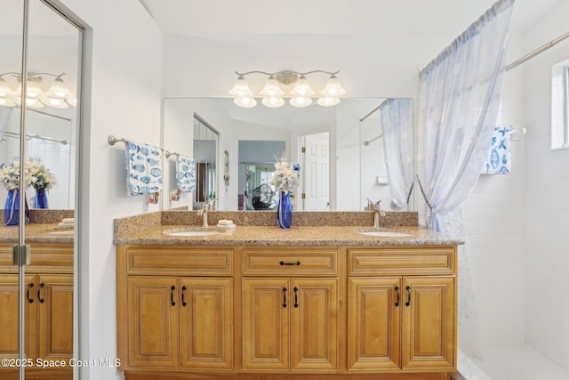 full bathroom with a tile shower, double vanity, and a sink