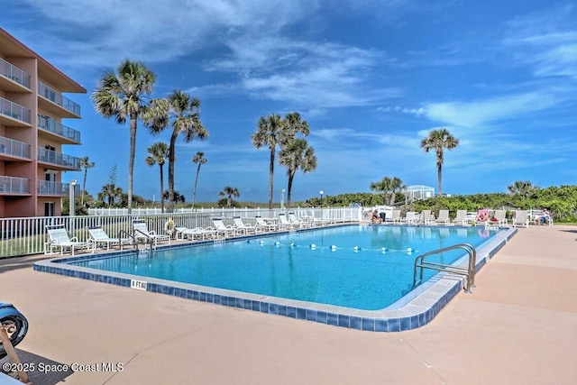 community pool featuring a patio area and fence