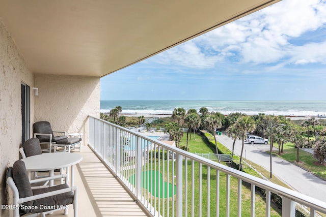 balcony with a water view and a beach view