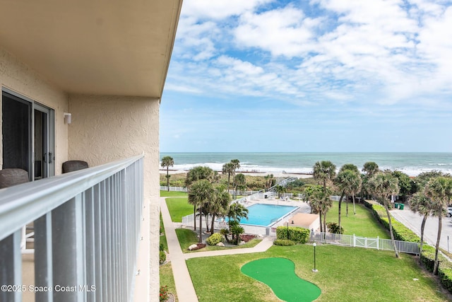 balcony with a water view and a view of the beach