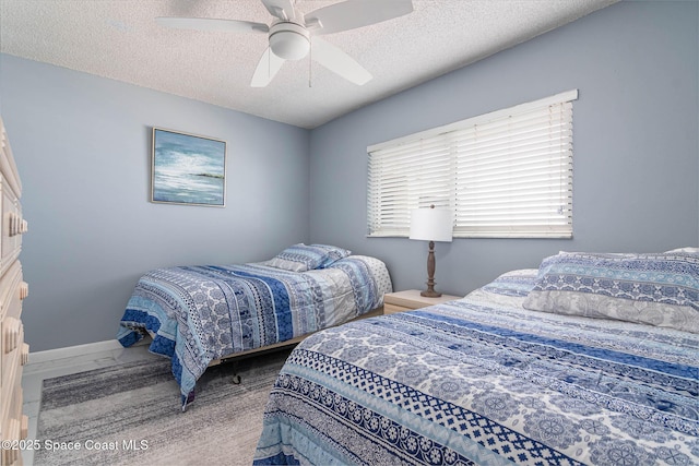 bedroom featuring ceiling fan, baseboards, and a textured ceiling