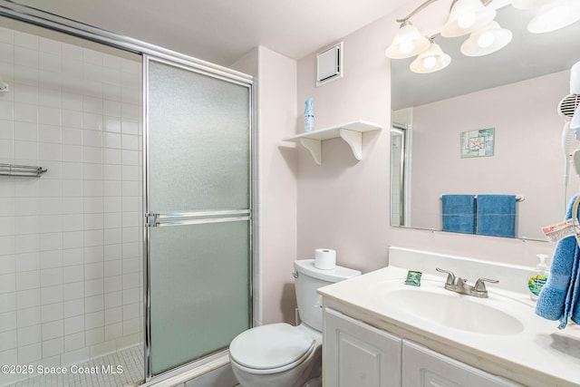 bathroom featuring a shower stall, toilet, and vanity