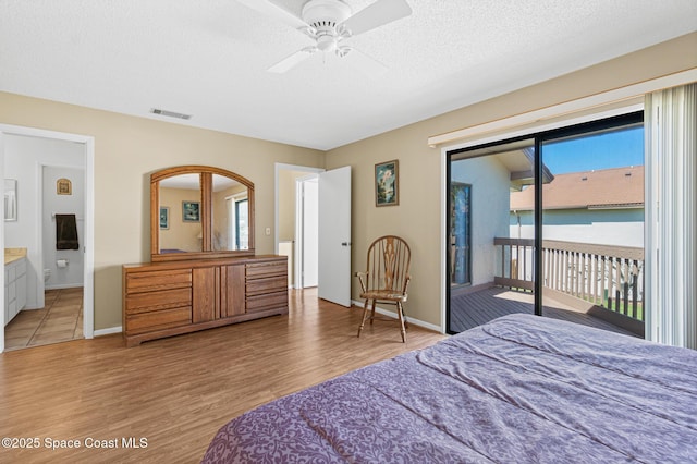 bedroom with access to outside, visible vents, a textured ceiling, light wood-type flooring, and baseboards