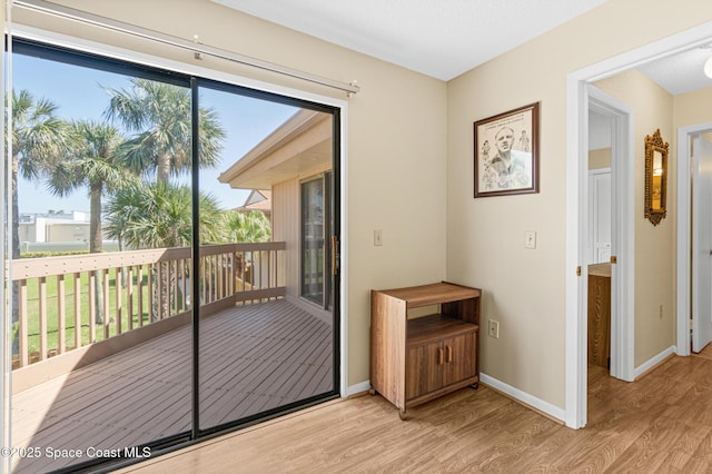 entryway with light wood-type flooring, plenty of natural light, and baseboards