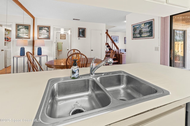 kitchen featuring light countertops, a sink, visible vents, and washer and clothes dryer