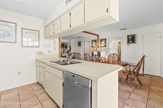 kitchen with visible vents, a peninsula, stainless steel dishwasher, a sink, and light tile patterned flooring