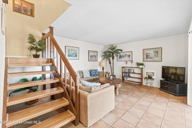 living room featuring stairway, a textured ceiling, and light tile patterned flooring