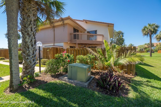 exterior space featuring a yard, fence, and a tiled roof