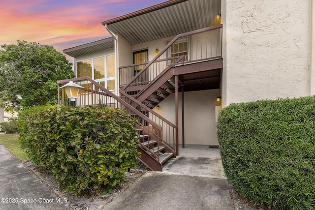 exterior entry at dusk featuring stucco siding