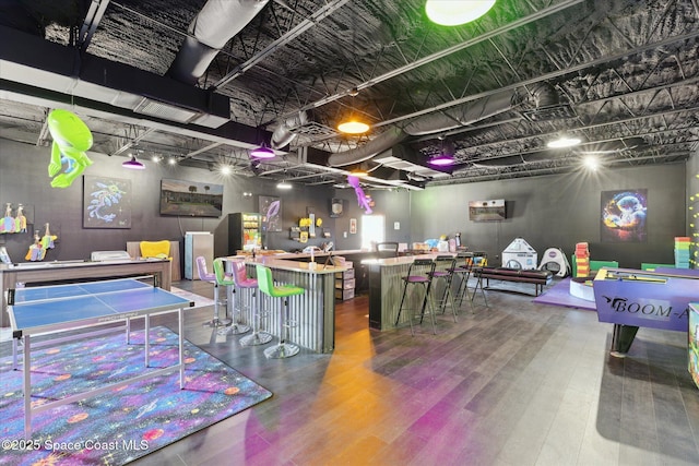 recreation room featuring a bar and wood finished floors