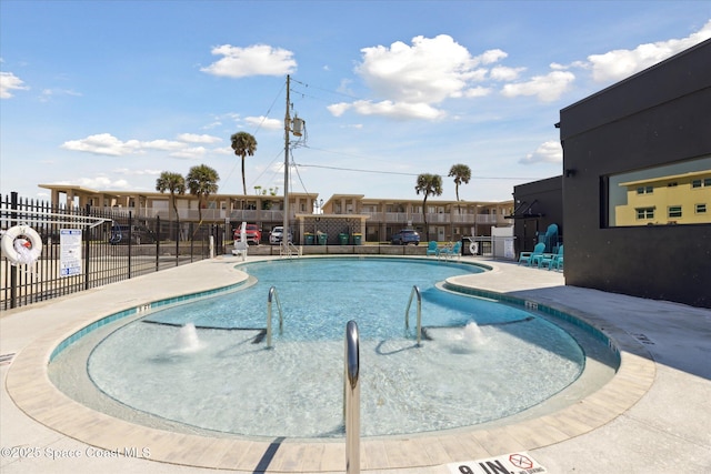 community pool featuring fence and a patio