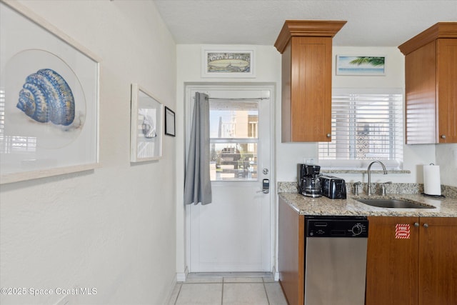 kitchen featuring dishwasher, a sink, and brown cabinets