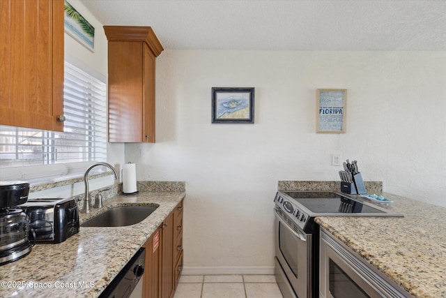 kitchen with light stone counters, brown cabinets, stainless steel electric stove, a sink, and light tile patterned flooring